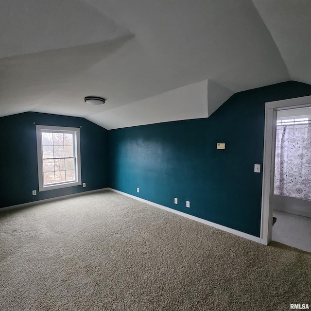 bonus room with lofted ceiling and carpet floors