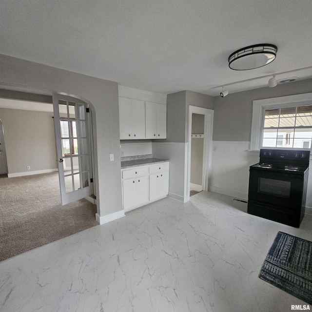 kitchen featuring white cabinets, a textured ceiling, and electric range