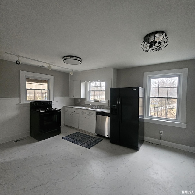 kitchen with white cabinetry, sink, black appliances, and a textured ceiling