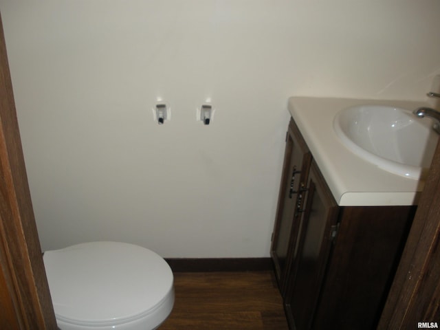 bathroom with wood-type flooring, vanity, and toilet