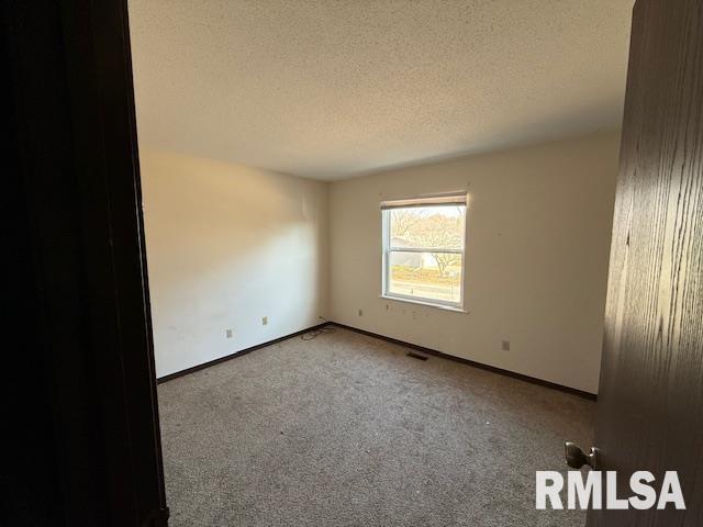 carpeted empty room with a textured ceiling