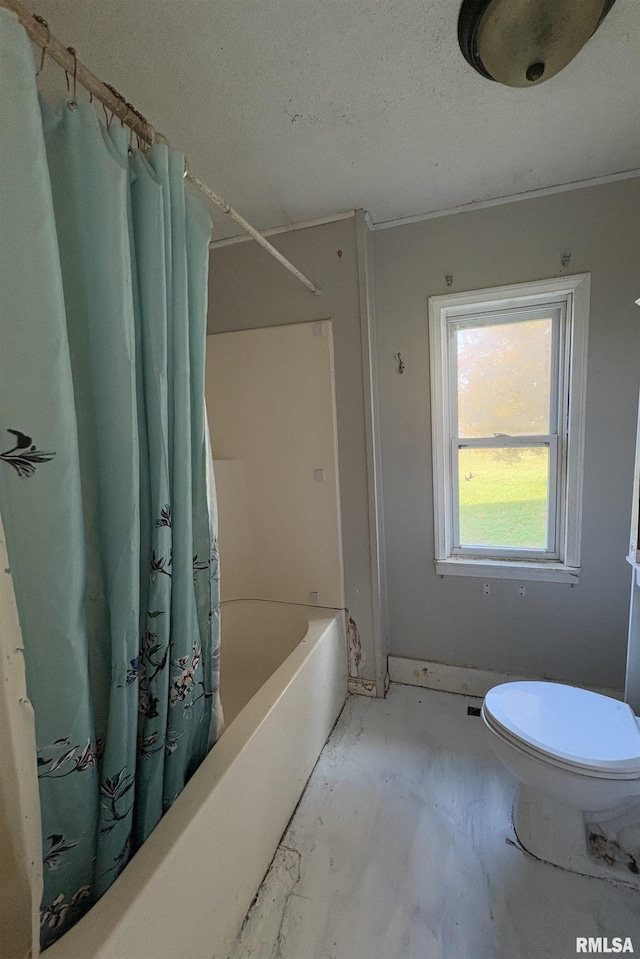 bathroom with toilet, a textured ceiling, and shower / bath combo