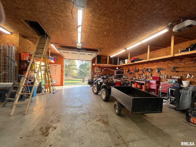 garage with a workshop area and a garage door opener