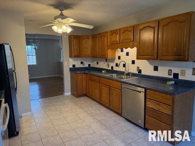 14892 Fowler School Rd, Marion, IL 62959 - kitchen with stainless steel dishwasher, a ceiling fan, brown cabinetry, a textured ceiling, and dark countertops