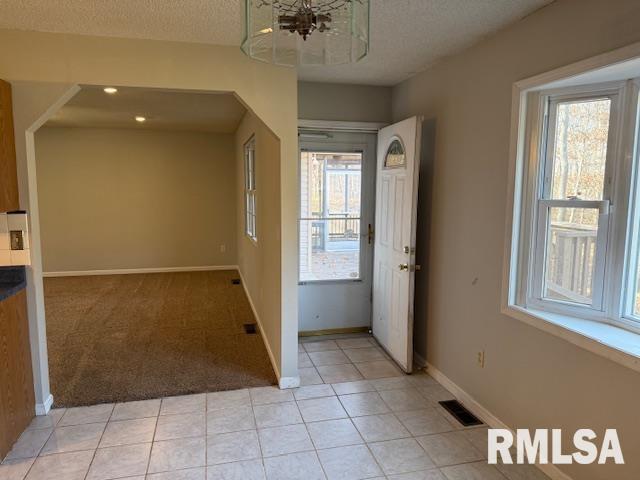 14892 Fowler School Rd, Marion, IL 62959 - entrance foyer featuring light tile patterned floors, light colored carpet, a chandelier, and a textured ceiling