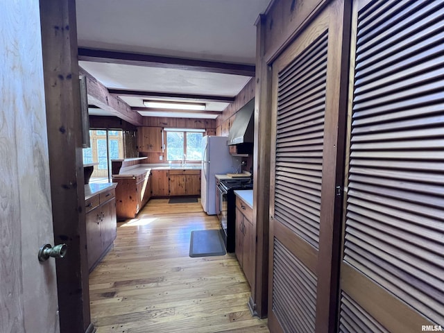 kitchen featuring sink, light hardwood / wood-style flooring, range hood, black range with electric cooktop, and beam ceiling