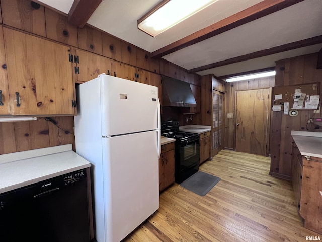 kitchen featuring black appliances, wall chimney range hood, wooden walls, beamed ceiling, and light hardwood / wood-style floors