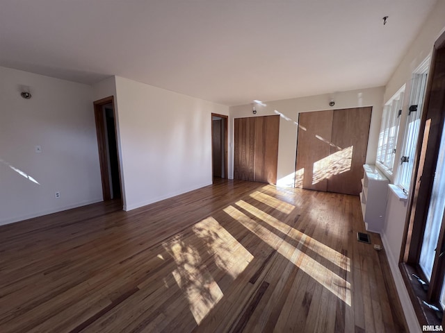 unfurnished room with dark wood-type flooring