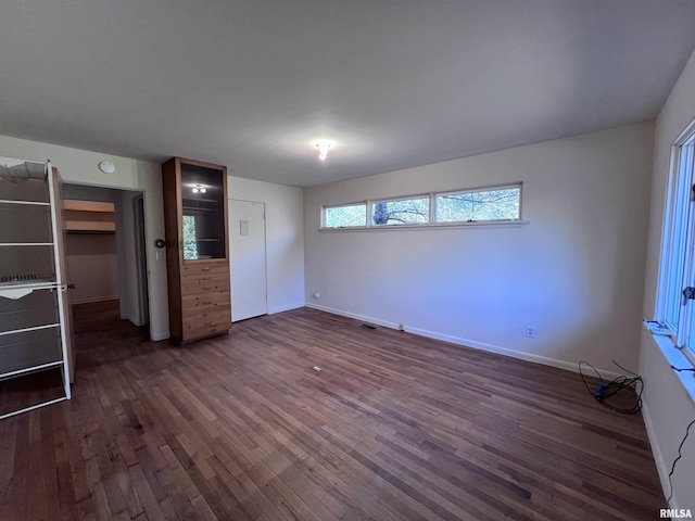 unfurnished bedroom with a closet and dark wood-type flooring