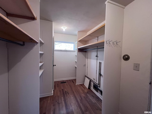 spacious closet with dark hardwood / wood-style flooring