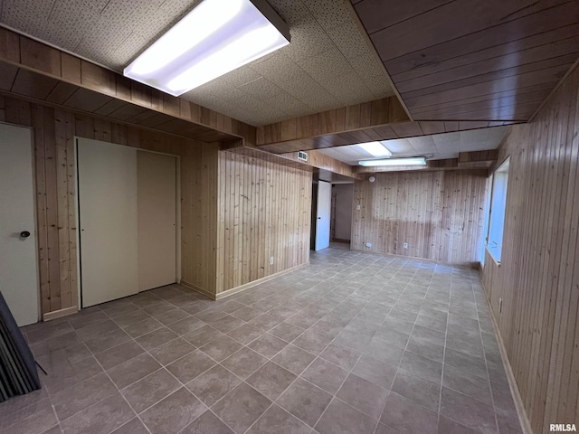 basement with light tile patterned flooring and wood walls