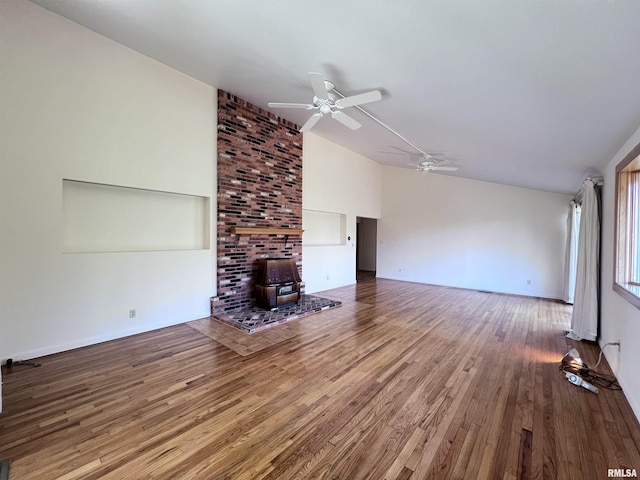 unfurnished living room featuring a wood stove, ceiling fan, and hardwood / wood-style flooring