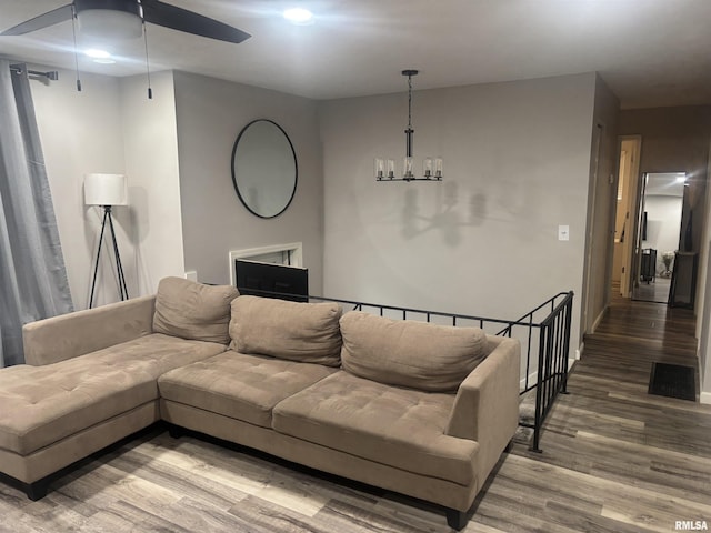 living room featuring hardwood / wood-style floors and ceiling fan with notable chandelier