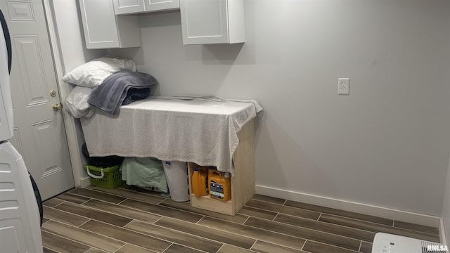 laundry area with cabinets and stacked washer / drying machine