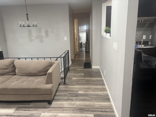 corridor featuring hardwood / wood-style floors and an inviting chandelier