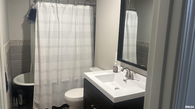 bathroom featuring vanity, toilet, and tile walls