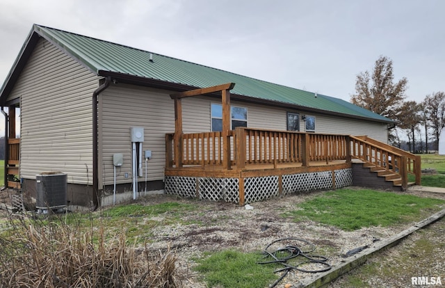 rear view of house featuring central AC unit and a wooden deck