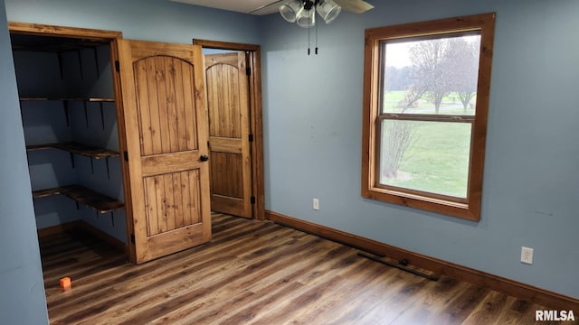 unfurnished bedroom featuring dark hardwood / wood-style floors and ceiling fan