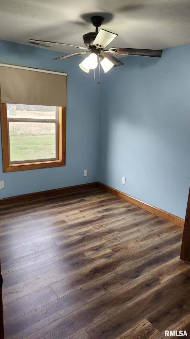 empty room with dark hardwood / wood-style flooring and ceiling fan