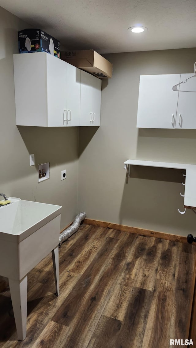 clothes washing area featuring hookup for an electric dryer, hookup for a washing machine, dark hardwood / wood-style floors, and cabinets