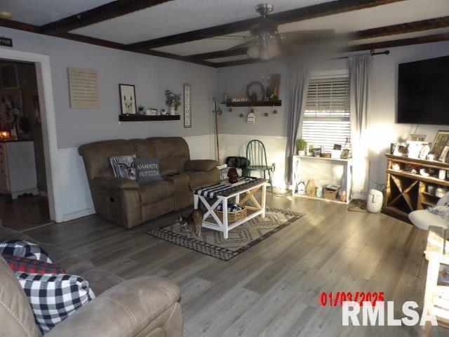 living room with beamed ceiling, hardwood / wood-style flooring, and ceiling fan