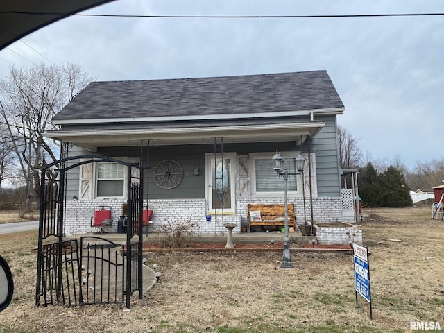 view of front of home featuring a porch, brick siding, and a shingled roof