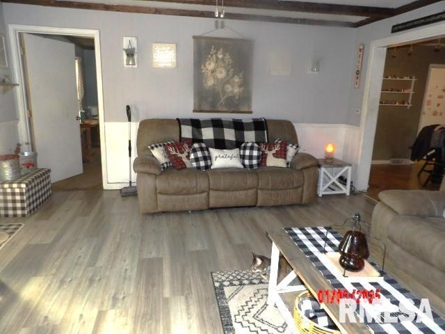 living room with beam ceiling and wood finished floors