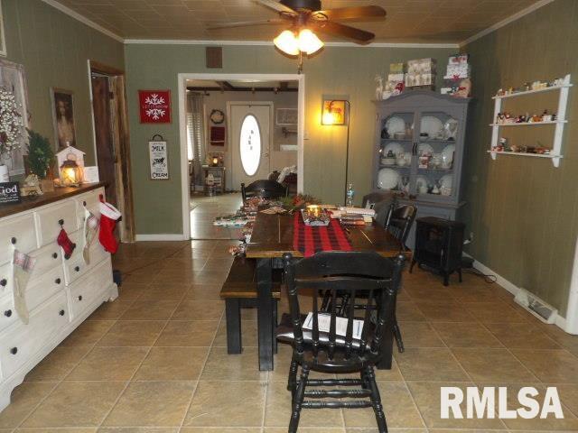 dining area featuring light tile patterned floors, baseboards, a ceiling fan, and crown molding