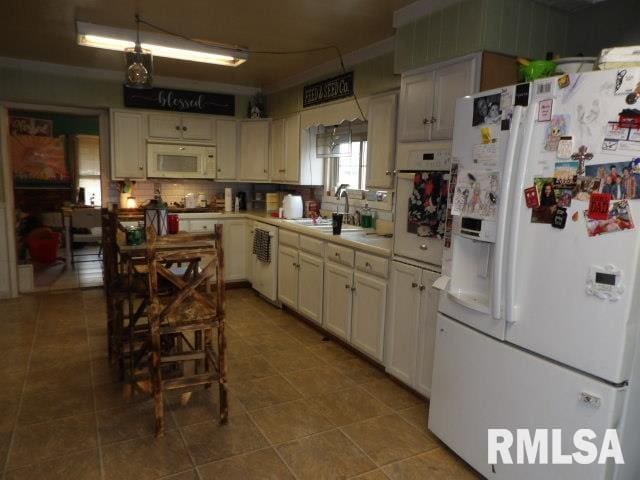 kitchen with white appliances, tasteful backsplash, tile patterned floors, light countertops, and a sink