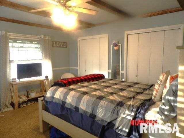 bedroom with multiple closets, carpet, beam ceiling, and a ceiling fan