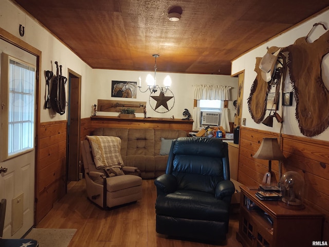 sitting room featuring wood-type flooring, cooling unit, a notable chandelier, and wood walls