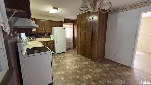 kitchen with white refrigerator, sink, tasteful backsplash, a notable chandelier, and range