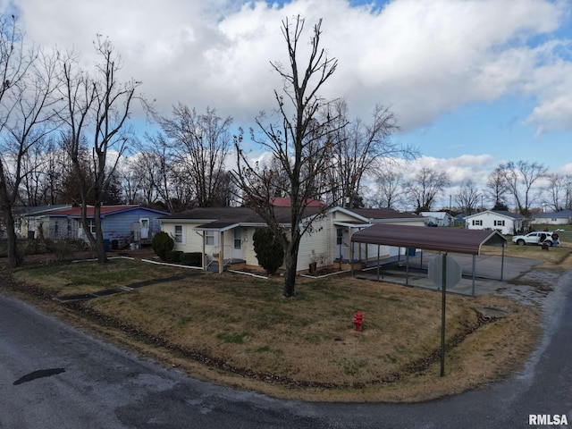 view of front of home with a front yard and a carport