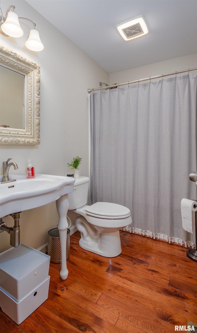 bathroom with toilet and hardwood / wood-style flooring