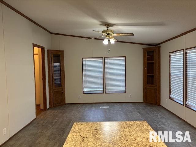 empty room with lofted ceiling, ceiling fan, and crown molding