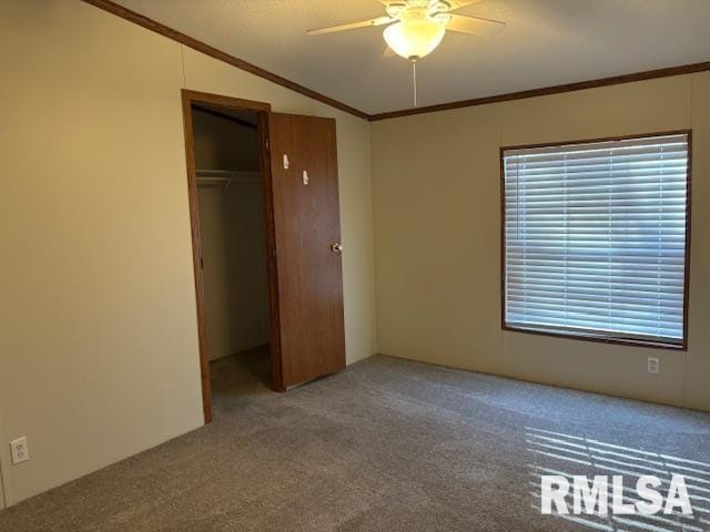 unfurnished bedroom with lofted ceiling, crown molding, ceiling fan, light colored carpet, and a closet