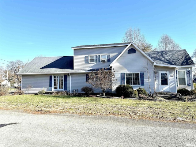 traditional-style house featuring french doors and a front lawn