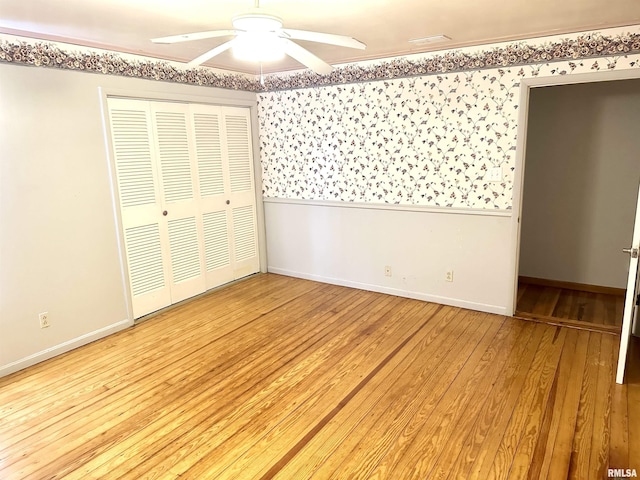 unfurnished bedroom with a closet, light hardwood / wood-style floors, and ceiling fan