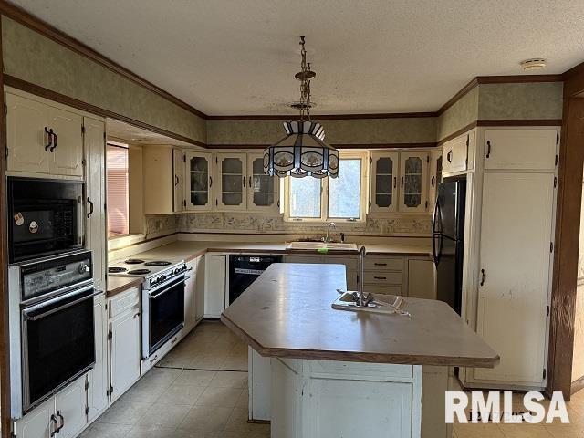 kitchen with sink, black appliances, pendant lighting, a notable chandelier, and a kitchen island