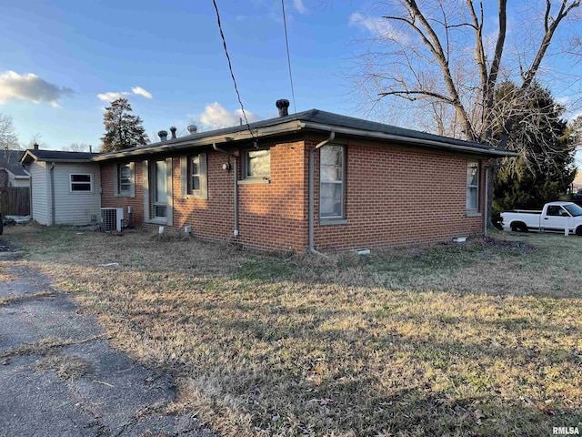 exterior space with central AC unit and a front lawn