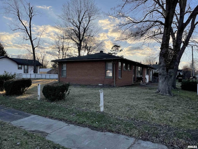 property exterior at dusk with a yard