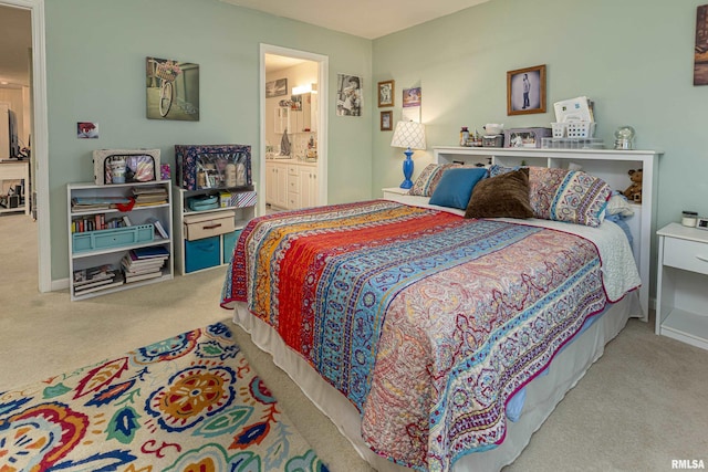 bedroom with light carpet and connected bathroom