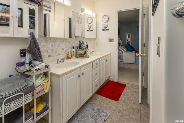 bathroom with tile patterned flooring, vanity, and tasteful backsplash