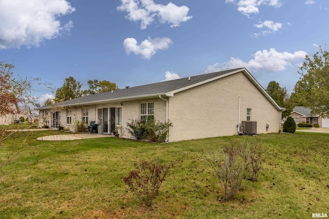 rear view of house featuring central AC, a yard, and a patio