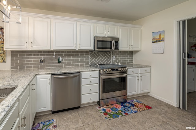 kitchen featuring backsplash, light tile patterned flooring, light stone counters, white cabinetry, and stainless steel appliances