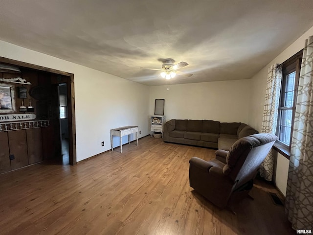 living room with light hardwood / wood-style flooring and ceiling fan