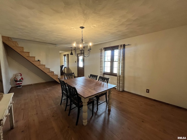 dining room featuring dark wood-type flooring and an inviting chandelier