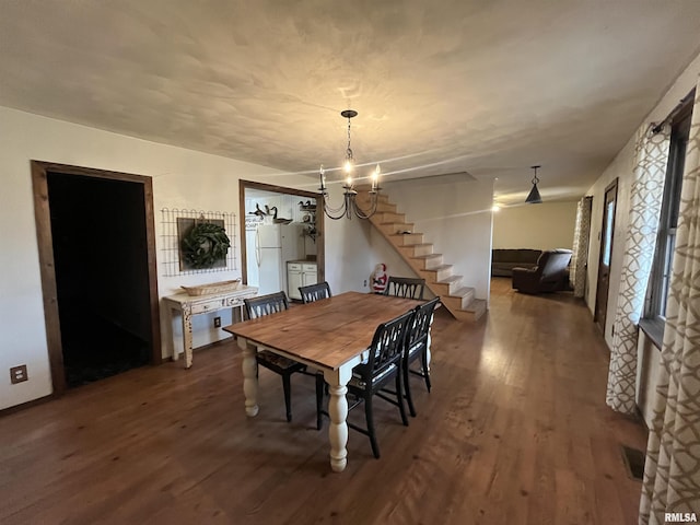 dining room featuring dark hardwood / wood-style flooring and an inviting chandelier