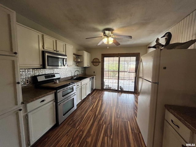 kitchen featuring backsplash, stainless steel appliances, ceiling fan, sink, and white cabinetry