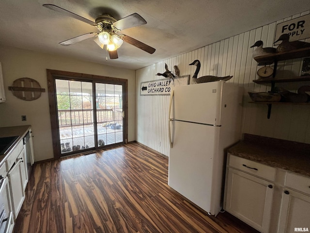 kitchen with dishwasher, ceiling fan, white fridge, dark hardwood / wood-style flooring, and white cabinetry